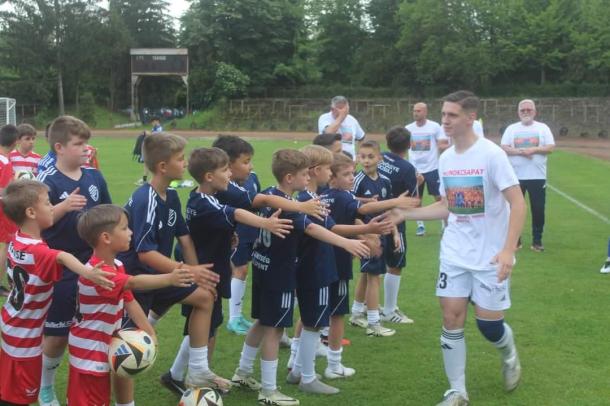 Az utánpótlás fiatal játékosainak ad pacsit az egyik focista.