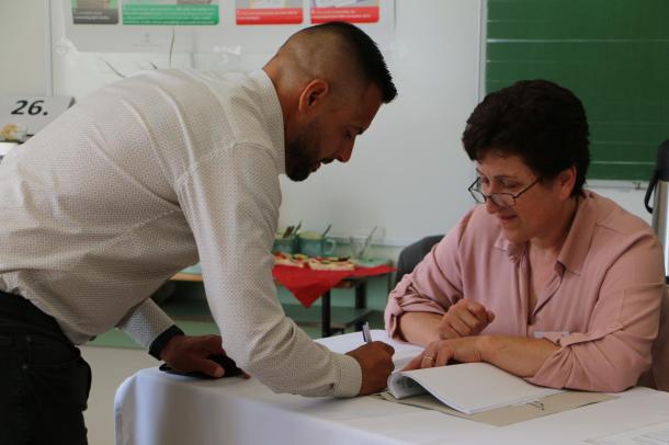 Váradi József roma nemzetiségi képviselőjelölt éppen aláírja a névjegyzéket.