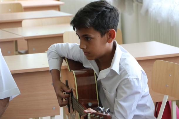 Az egyik diák gitárral a kezében.