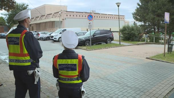 Rendőrök figyelik a forgalmat az iskola előtti zebránál.