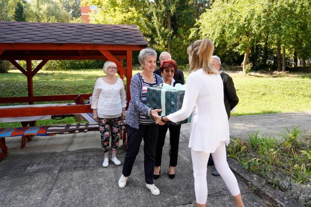 Nyújtsunk Kezet Mindenkinek Egyesület képviselői átnyújtják az új függönyt az intézmény megbízott vezetőjének.