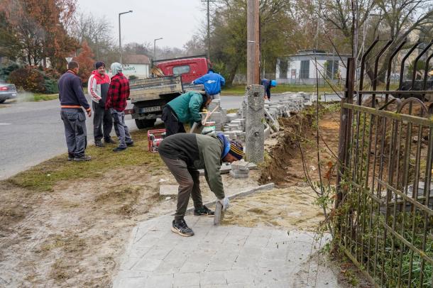 Térkövezik a járdát a szakemberek.