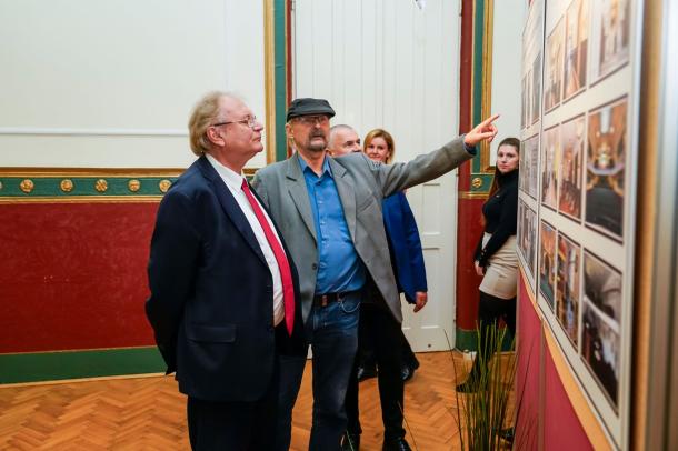 Dr. Tóth István a művészeti csoportokról készült fotókat mutatja Hiller Istvánnak.