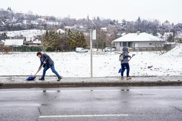 Az Ózdi Városüzemeltető Intézmény munkatársai kézi erővel takarítják az utakat.